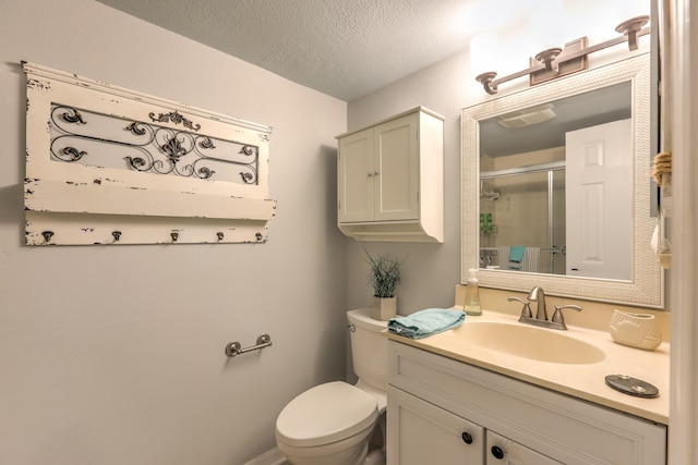 bathroom with walk in shower, vanity, toilet, and a textured ceiling