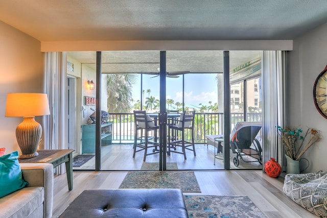 living room featuring expansive windows, light hardwood / wood-style flooring, and a textured ceiling