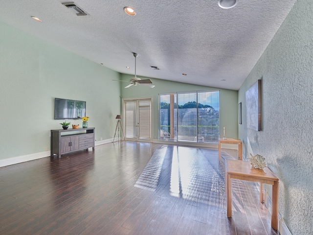 living room with ceiling fan, a textured ceiling, dark hardwood / wood-style floors, and vaulted ceiling