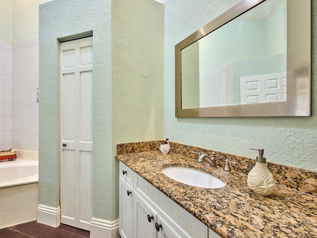 bathroom featuring tile patterned flooring, vanity, and a bathing tub