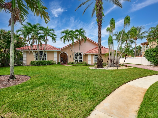 mediterranean / spanish-style home with a front lawn