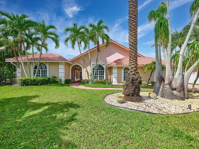 mediterranean / spanish-style home with a front lawn