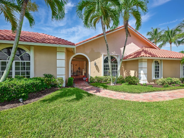 mediterranean / spanish-style home featuring a front yard