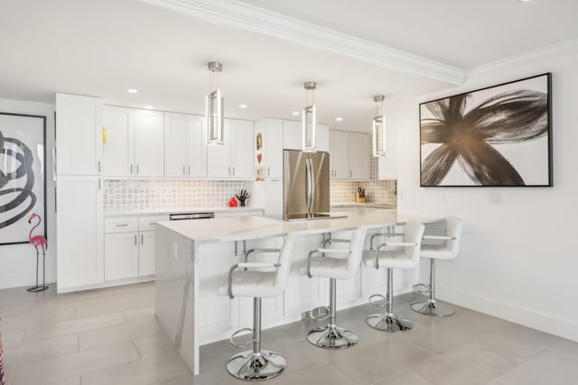 kitchen featuring a kitchen island, white cabinetry, hanging light fixtures, and stainless steel refrigerator