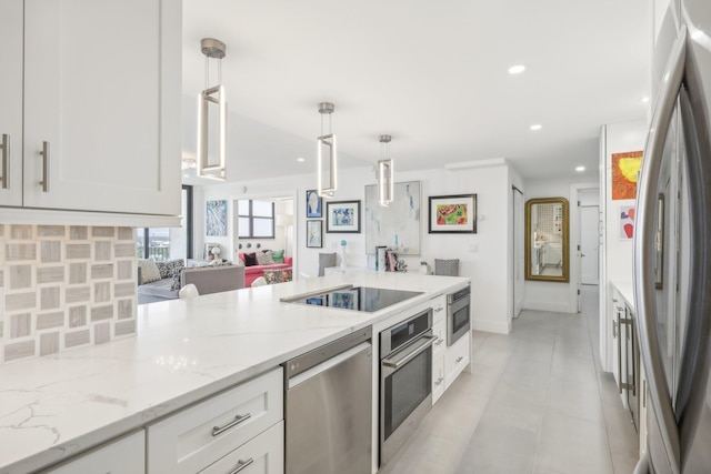 kitchen with stainless steel appliances, light stone counters, backsplash, decorative light fixtures, and white cabinets