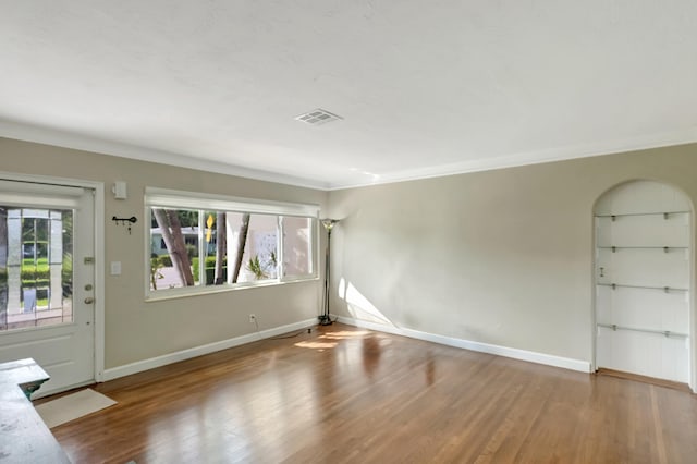 spare room featuring crown molding and wood-type flooring