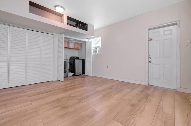 unfurnished living room featuring light hardwood / wood-style flooring and washer and dryer