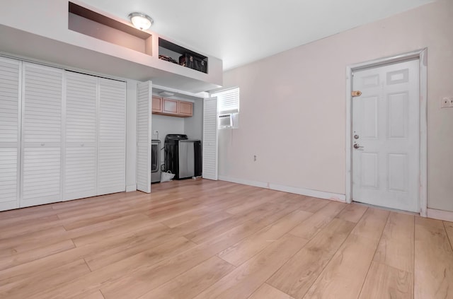 unfurnished living room with separate washer and dryer and light wood finished floors