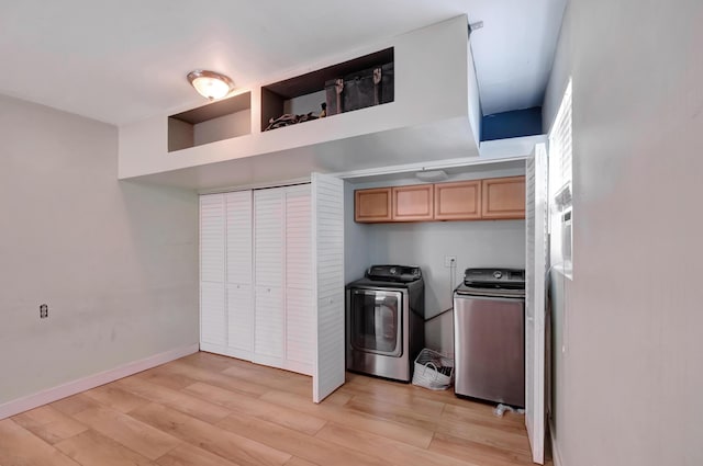 laundry room with washing machine and clothes dryer, laundry area, baseboards, and light wood finished floors