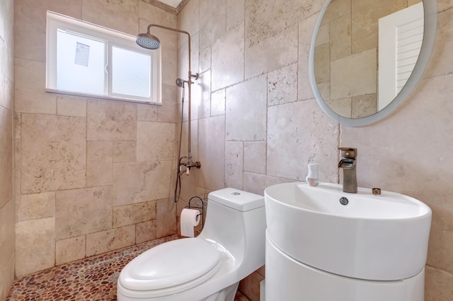 bathroom featuring a tile shower, toilet, tile walls, and vanity