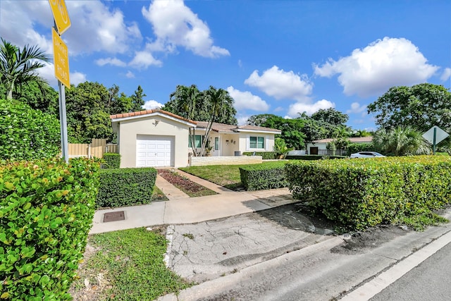 view of front of property featuring a front yard and a garage