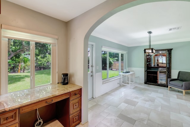 interior space featuring built in desk, light stone counters, and pendant lighting