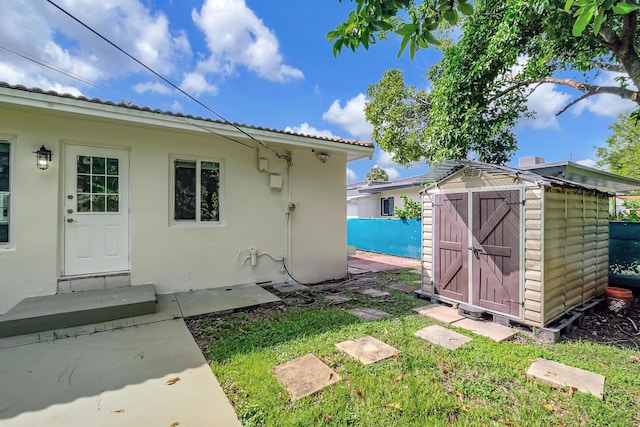 exterior space featuring an outdoor structure, stucco siding, and a shed
