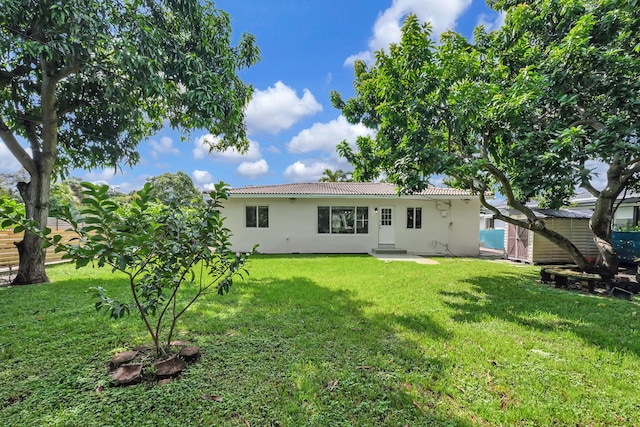 rear view of house featuring a yard