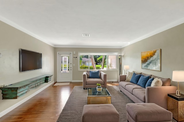 living room with crown molding and hardwood / wood-style flooring