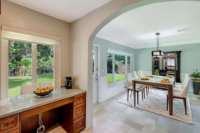 dining space with ornamental molding and a wealth of natural light