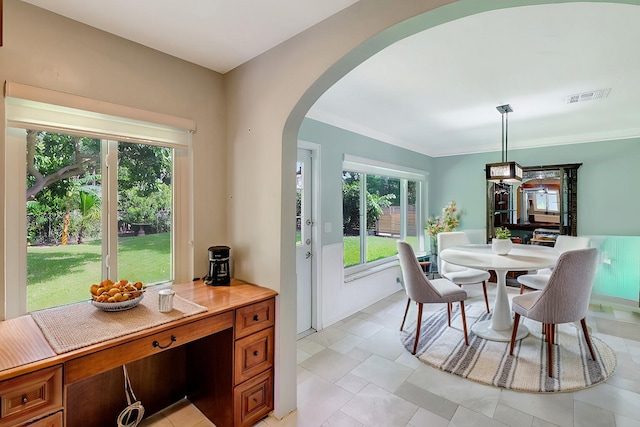 tiled dining room featuring crown molding