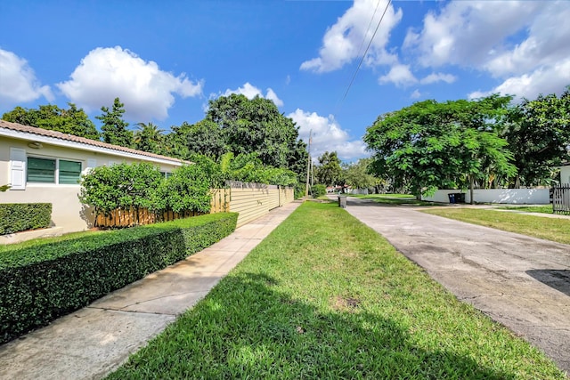 view of community with a yard and fence