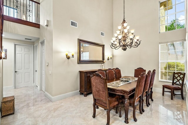 foyer entrance featuring a towering ceiling and a chandelier