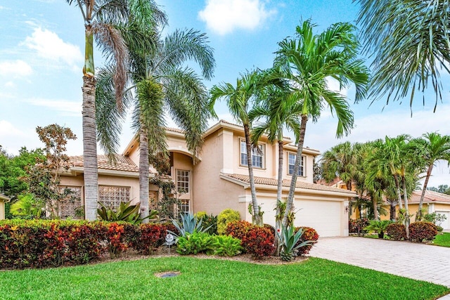 mediterranean / spanish-style house featuring a front yard and a garage