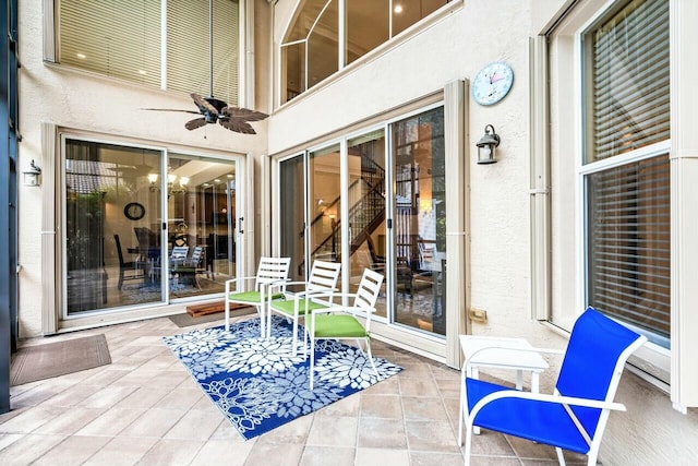 unfurnished sunroom with ceiling fan