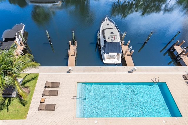 view of swimming pool with a water view and a dock