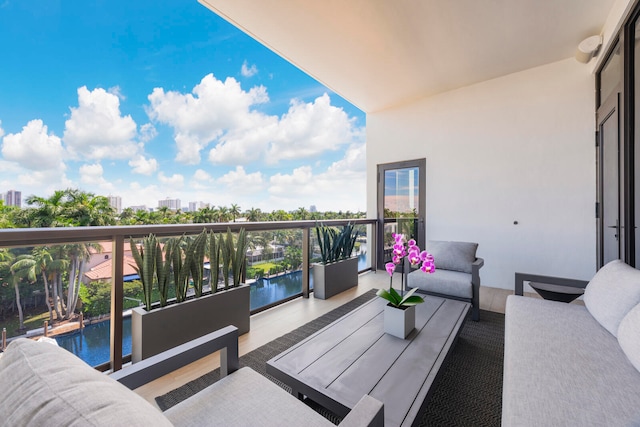 balcony with an outdoor hangout area and a water view