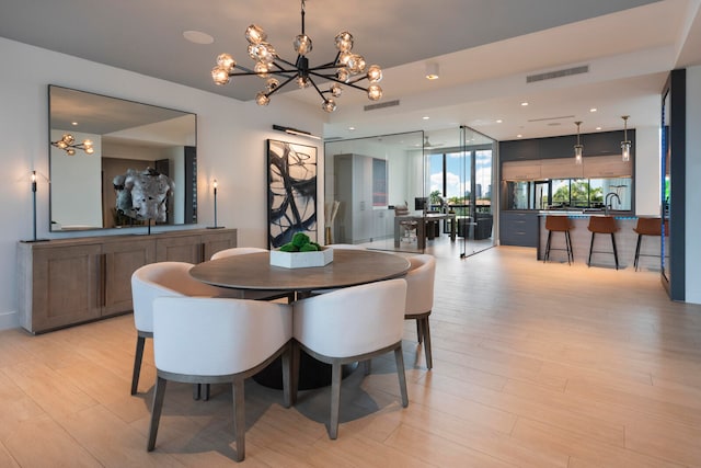 dining space with light wood-type flooring and a chandelier