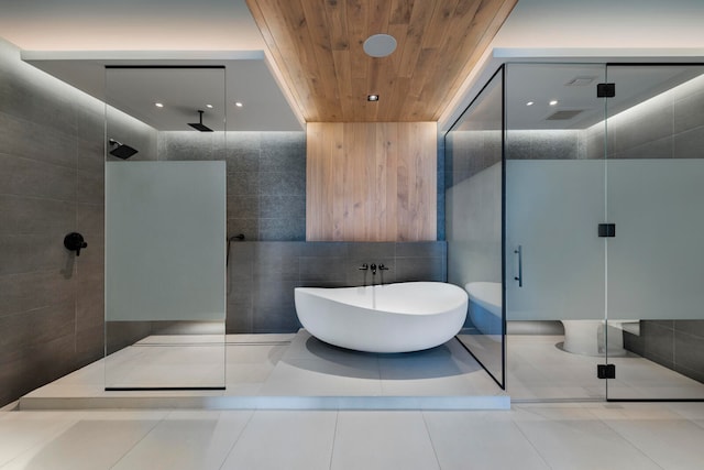 bathroom featuring tile walls, tile patterned floors, and separate shower and tub