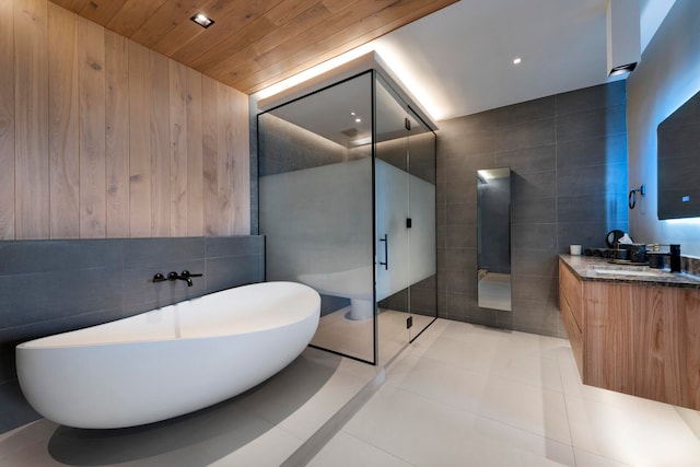 bathroom featuring vanity, tile patterned floors, and tile walls