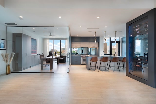 kitchen featuring pendant lighting, a wealth of natural light, and a kitchen bar