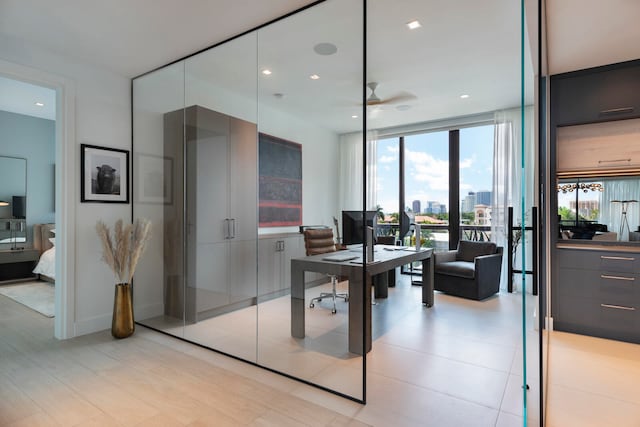 office with ceiling fan and a wall of windows