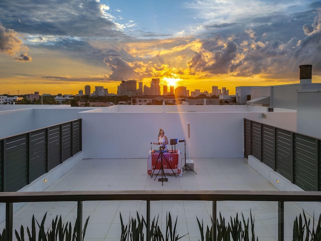 patio terrace at dusk featuring a balcony