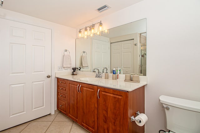 bathroom with tile patterned flooring, vanity, and toilet