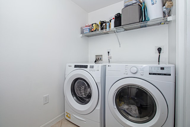 laundry area with washer and clothes dryer and light tile patterned flooring