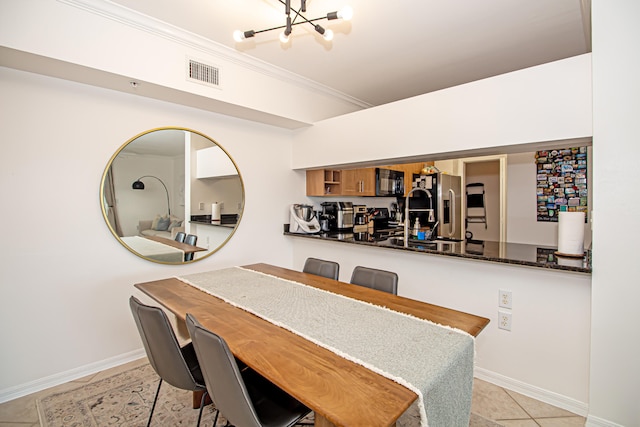 dining area with crown molding, sink, and light tile patterned floors