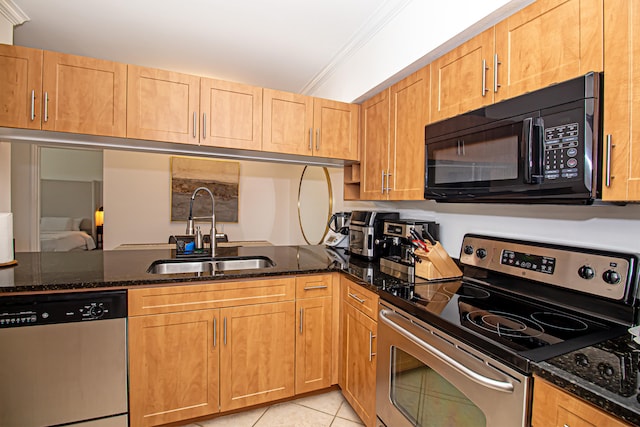 kitchen featuring ornamental molding, dark stone countertops, sink, and stainless steel appliances