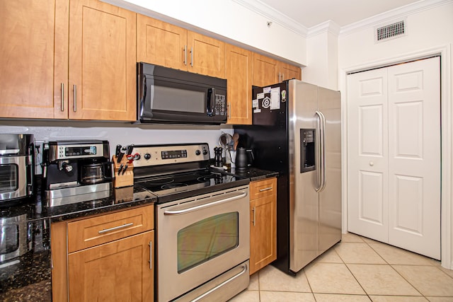 kitchen featuring appliances with stainless steel finishes, light tile patterned floors, dark stone counters, and ornamental molding