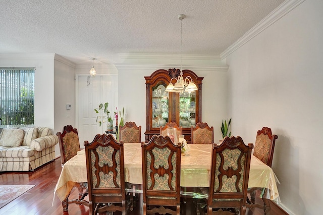 dining area with a notable chandelier, ornamental molding, a textured ceiling, and hardwood / wood-style floors