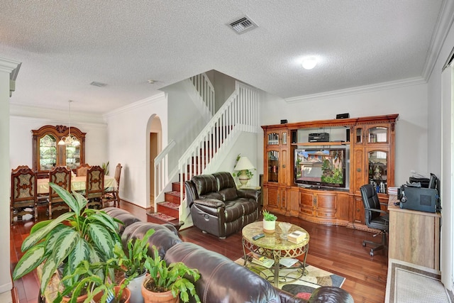 living room featuring ornamental molding, a textured ceiling, hardwood / wood-style flooring, and a notable chandelier