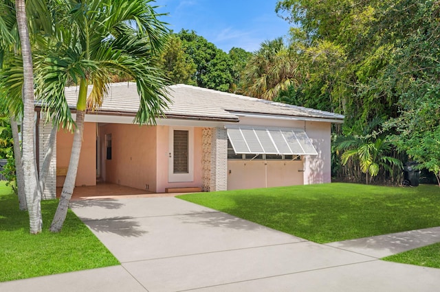 view of front facade featuring stucco siding, a carport, concrete driveway, and a front yard