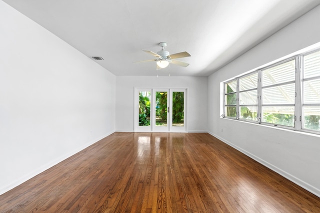 empty room with a ceiling fan, visible vents, hardwood / wood-style flooring, and a healthy amount of sunlight