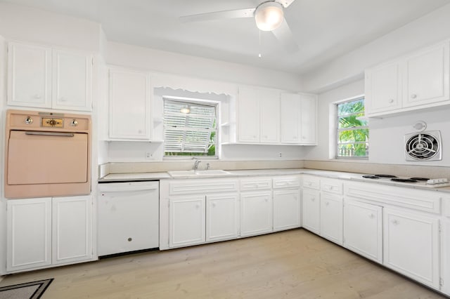 kitchen featuring visible vents, a sink, white cabinetry, and white appliances