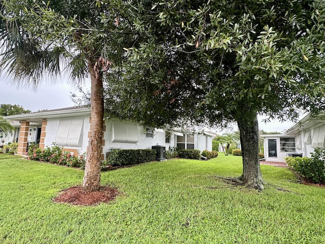 view of front facade featuring a front lawn and central AC