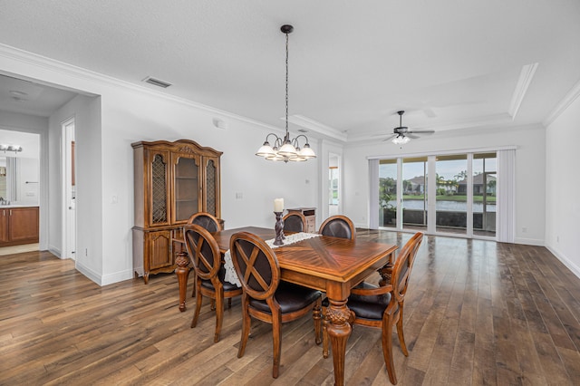 dining area with crown molding, dark hardwood / wood-style floors, a raised ceiling, and ceiling fan with notable chandelier