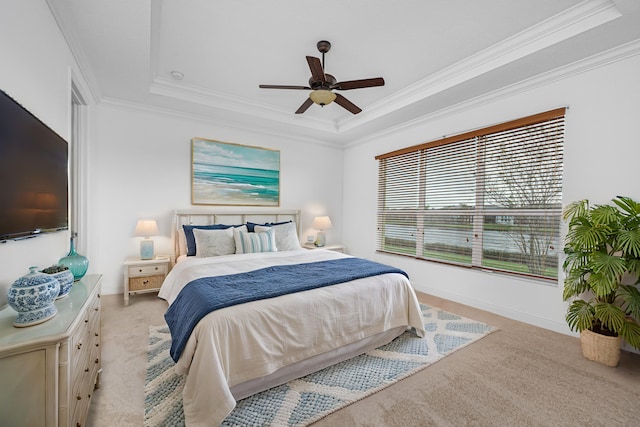 carpeted bedroom with a raised ceiling, ornamental molding, and ceiling fan