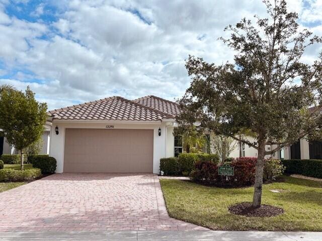 mediterranean / spanish home with a garage and a front yard