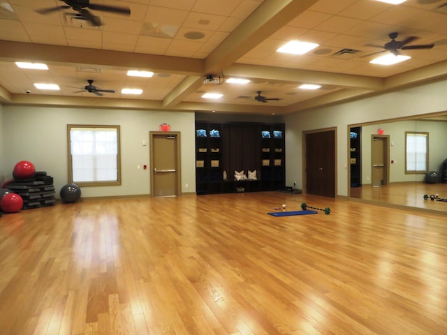 exercise room featuring ceiling fan, a paneled ceiling, and hardwood / wood-style floors