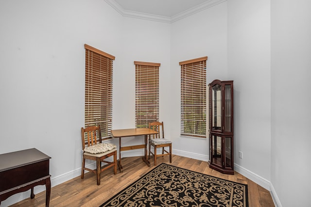 living area with crown molding and light wood-type flooring