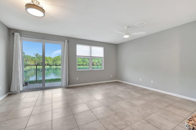 spare room featuring light tile patterned floors and ceiling fan